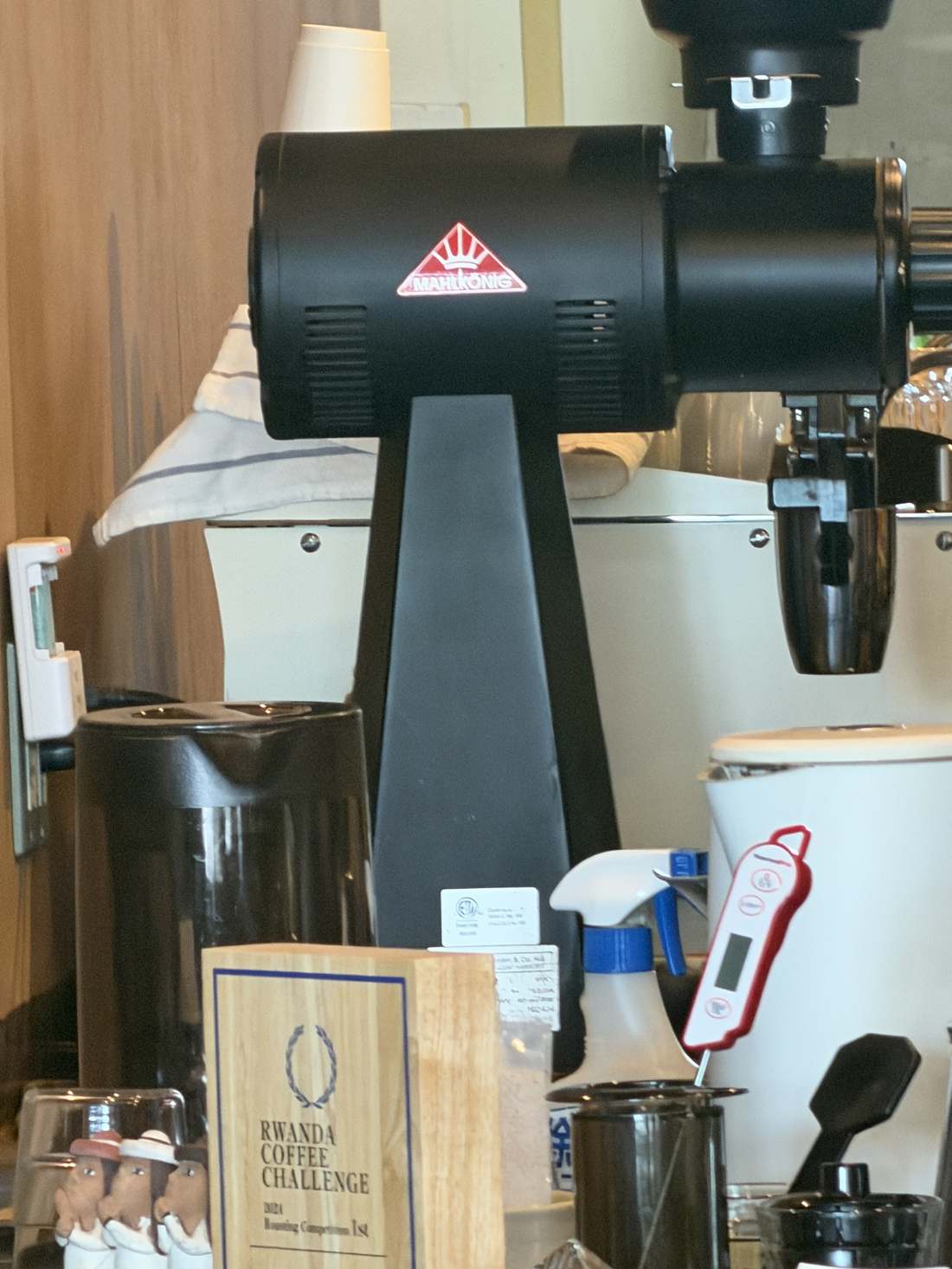 カウンターのMahlkönig電動グラインダーと、RWANDA COFFEE CHALLENGE 2024のトロフィー