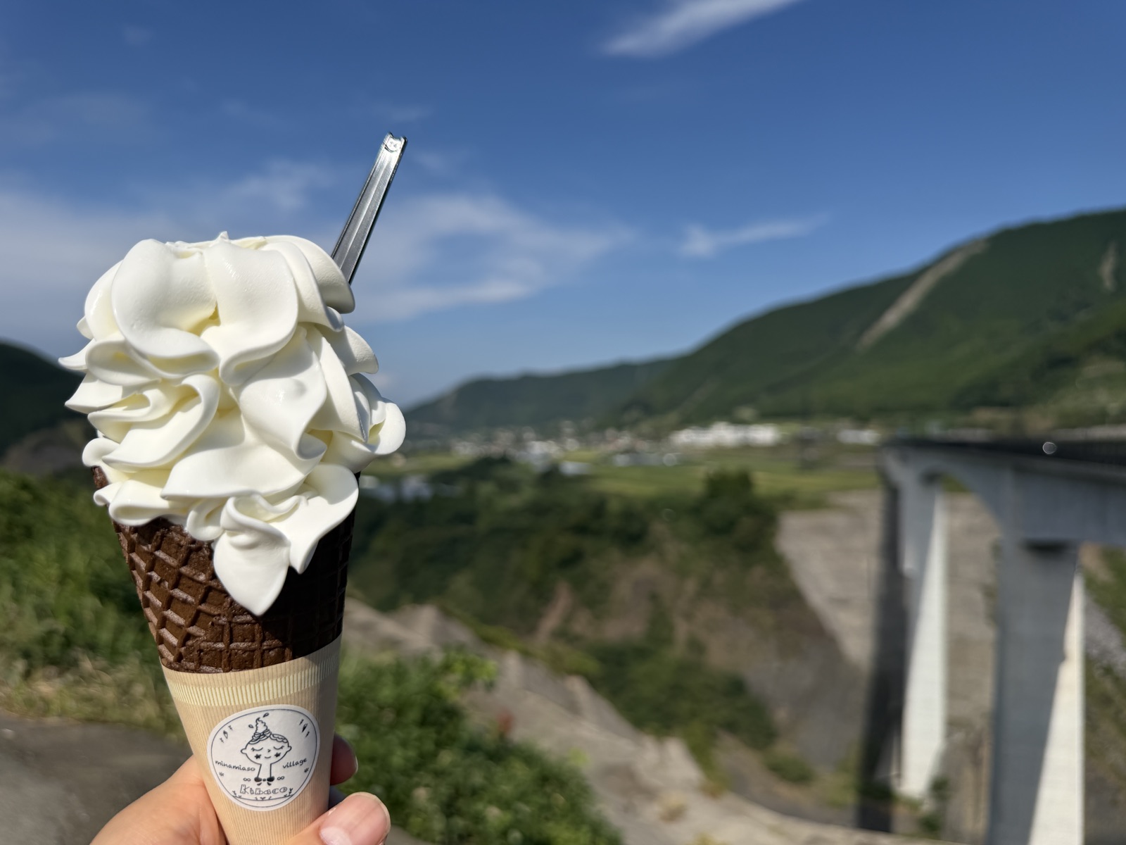新阿蘇大橋を背景に手に持ったkibacoのリボンソフト